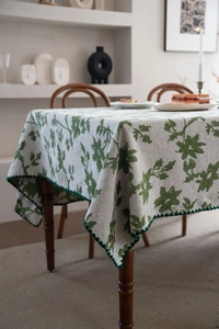 Detailansicht der grünen Blumen-Jacquard-Tischdecke mit eleganten Wellenkanten