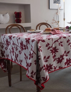 Vista dettagliata della tovaglia jacquard rossa con bordo smerlato su un tavolo da pranzo