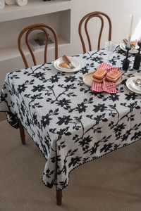 Dettaglio macro della tovaglia jacquard italiana con motivi floreali neri e trama tessuta