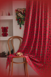 Detail of red Christmas curtain with green tree prints and decorative pom-pom trim