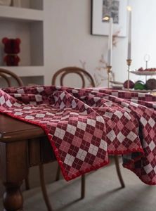 Detail of red and white checkered tablecloth with decorative pom-pom fringe edges