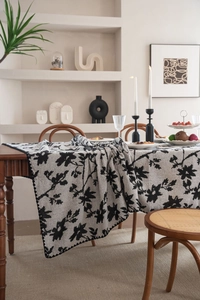 Dettaglio del runner da tavola jacquard bianco e nero con eleganti ricami di foglie