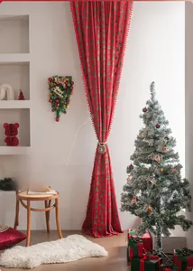 Detail of red Christmas curtain with green tree patterns and hanging pom-pom fringe edge