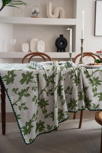 Detail der Jacquard-Blumentischdecke mit grünen Wellenkanten und Webstruktur