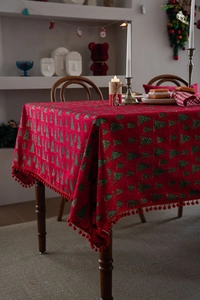 Detail der roten Weihnachts-Tischdecke mit Tannen-Print und dekorativer Bommel-Borte