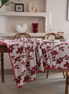 Dettaglio della tovaglia jacquard floreale con bordo in pizzo rosso fatto a mano