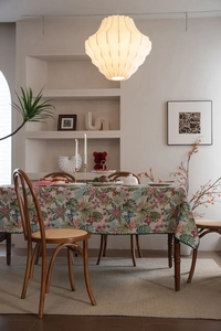 Close-up of bohemian jacquard tablecloth featuring green palm leaves and vintage floral patterns