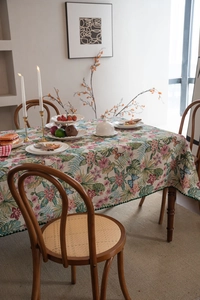 Detail of bohemian jacquard tablecloth with floral palm patterns and green tassel fringe