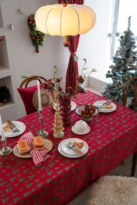 Detail der roten Weihnachts-Tischdecke mit Baummuster und weichen kleinen Bommeln