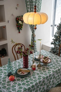 Close-up of Christmas tablecloth featuring green snowflake patterns and tassel edges