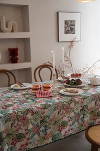 Detail of bohemian floral tablecloth showing green sawtooth edges and butterfly patterns