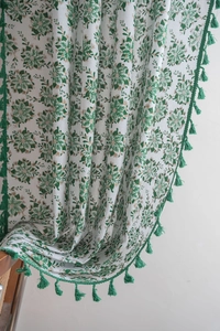 Detail of cream curtains with green floral print and matching fringe tassel edges