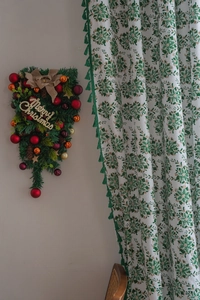 Detail of Christmas curtain with gold snowflake prints and green fringe trim decoration