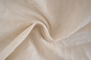 Detailed macro view of beige jacquard curtain fabric with classic damascus floral pattern