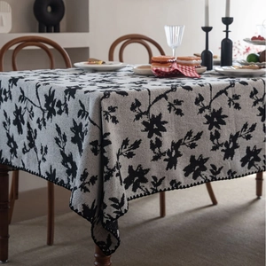 Tovaglia jacquard italiana con motivi floreali neri ed eleganti bordi ondulati