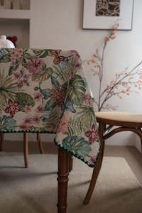 Detail of bohemian jacquard tablecloth featuring floral patterns and scalloped green edges