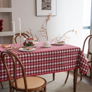 Red and white checkered tablecloth with lace edges on a wooden dining table