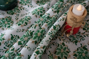 Macro view of festive green holly leaves and gold leaf patterns on cotton-linen fabric
