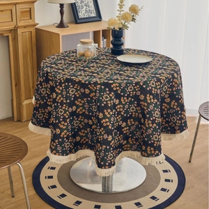 Round tablecloth with paisley floral pattern and cream tassel fringe in home setting