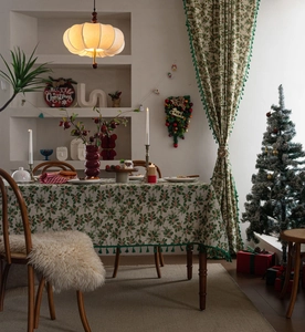 Detailed view of Christmas holly berry tablecloth with green pompom fringe edges