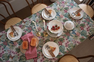 Detailed view of jacquard tablecloth featuring floral monstera patterns and butterfly motifs