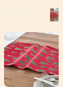 Detailed texture of red Christmas table runner with green tree patterns and linen style