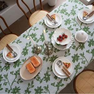 Rechteckige cremefarbene Tischdecke mit grünen floralen Jacquardmustern beim Essen