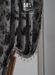 Detail of grey geometric floral curtains with cream tassels showing 50% shading effect