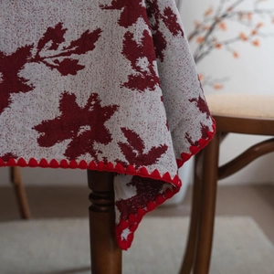 Tovaglia jacquard rossa con motivo floreale vintage e bordi smerlati su tavolo da pranzo