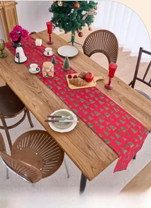Close-up of red Christmas table runner with gold dots and green tree patterns