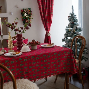 Rote Weihnachtstischdecke mit grünen Tannenmustern und roten Pompons für Esstische