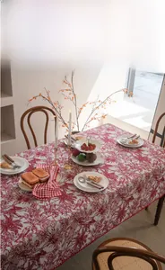 Detail of red floral embroidery on vintage festive tablecloth with woodland motifs