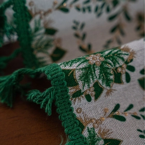 Christmas tablecloth with green leaf print, gold glitter accents and fringe edges