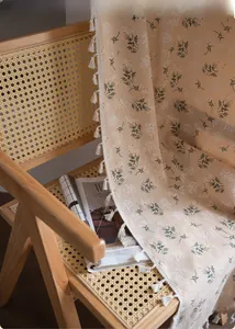Detailed close-up of floral print fabric with fringe tassels on a vintage chair
