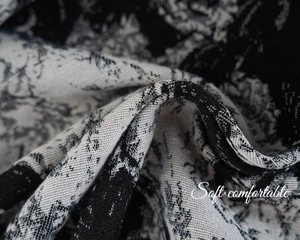 Detailed close-up of retro floral jacquard curtain fabric with soft textured black and white patterns