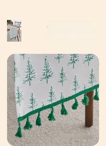 Detail of green handmade tassels and reinforced edges on a Christmas table runner