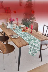 Detailed view of Christmas table runner with green holly pattern and handcrafted tassels
