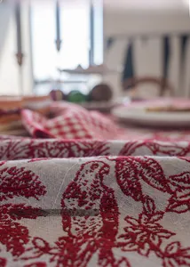 Macro shot of red and white jacquard tablecloth showing detailed floral weaving texture
