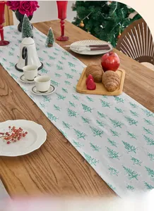 Detail of Christmas table runner with green pine tree pattern on grey fabric