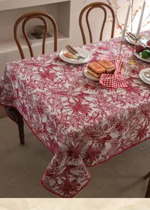 Detail of red Toile de Jouy jacquard tablecloth with animal motifs and scalloped edge finish