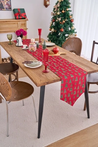 Detailed view of festive red Christmas table runner with green tree patterns and pointed ends