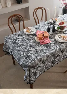 Detail of jacquard tablecloth featuring black and white plant and bird patterns in macro view