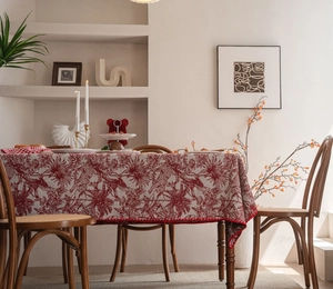 Detail of red and white jungle leopard pattern jacquard tablecloth with red piped edges