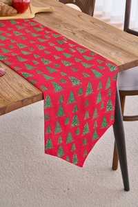 Close-up of red Christmas table runner with green trees and gold foil stamping details