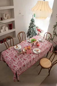 Close-up of red and beige jacquard tablecloth featuring vintage floral and butterfly patterns