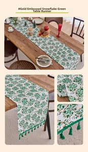 Close-up of green edelweiss print with gold stamping and fringe edges on a table runner