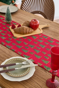 Detail view of red Christmas table runner with green tree patterns and gold stamping foil