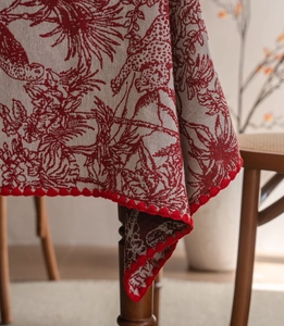 Close-up of jacquard fabric tablecloth with floral patterns and red crochet lace edges