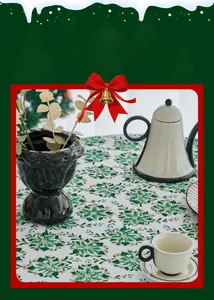 Close-up of festive green Christmas tablecloth with elegant tea set on a round table