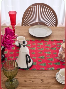 Detail of red Christmas table runner featuring green and gold glitter tree patterns